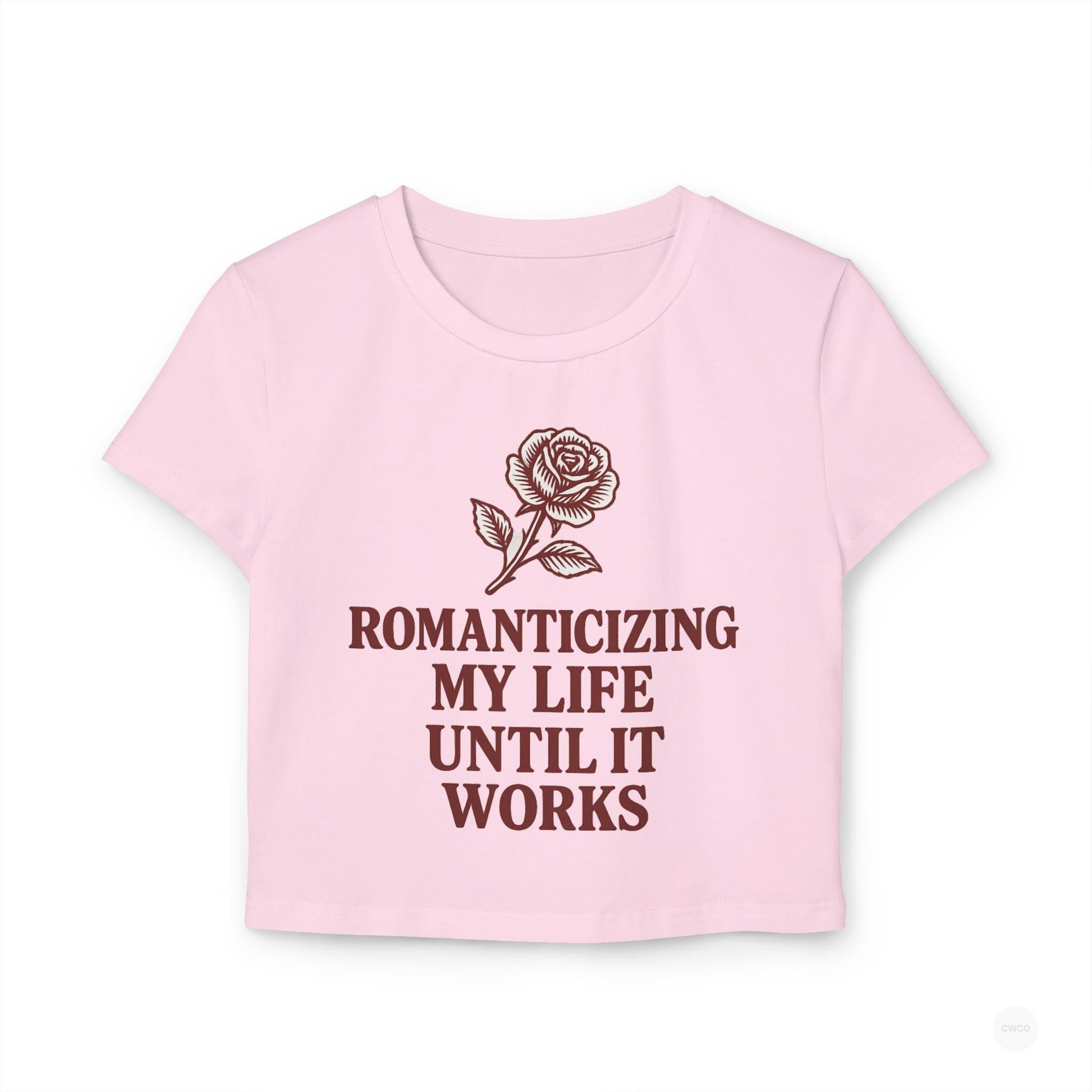 Pink t-shirt with a rose graphic and text on a white background