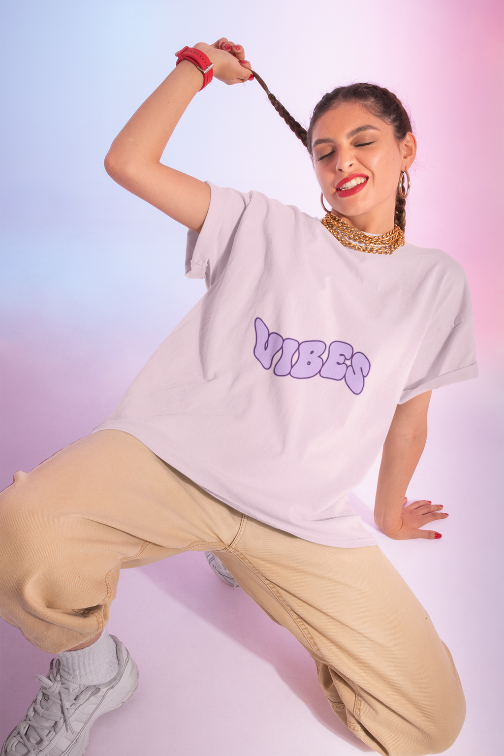 Person wearing a white t-shirt with 'VIBES' text, beige pants, and gray sneakers on a gradient background.
